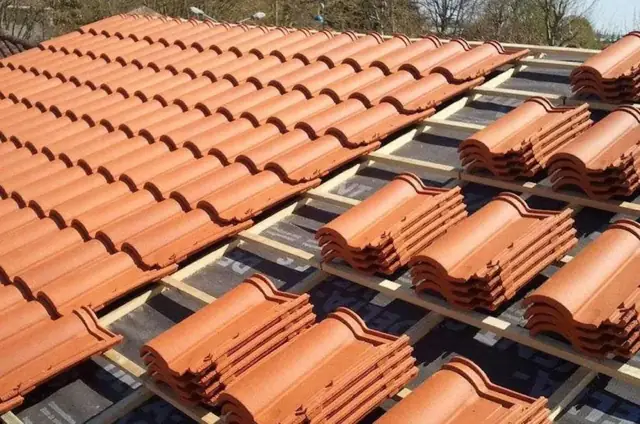 Pose de tuiles neuves sur une toiture aux Pujols